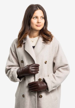 Beige wool coat with double-breasted design and gold buttons. Brown leather gloves with three seams, fitted styling, and minimalistic design.