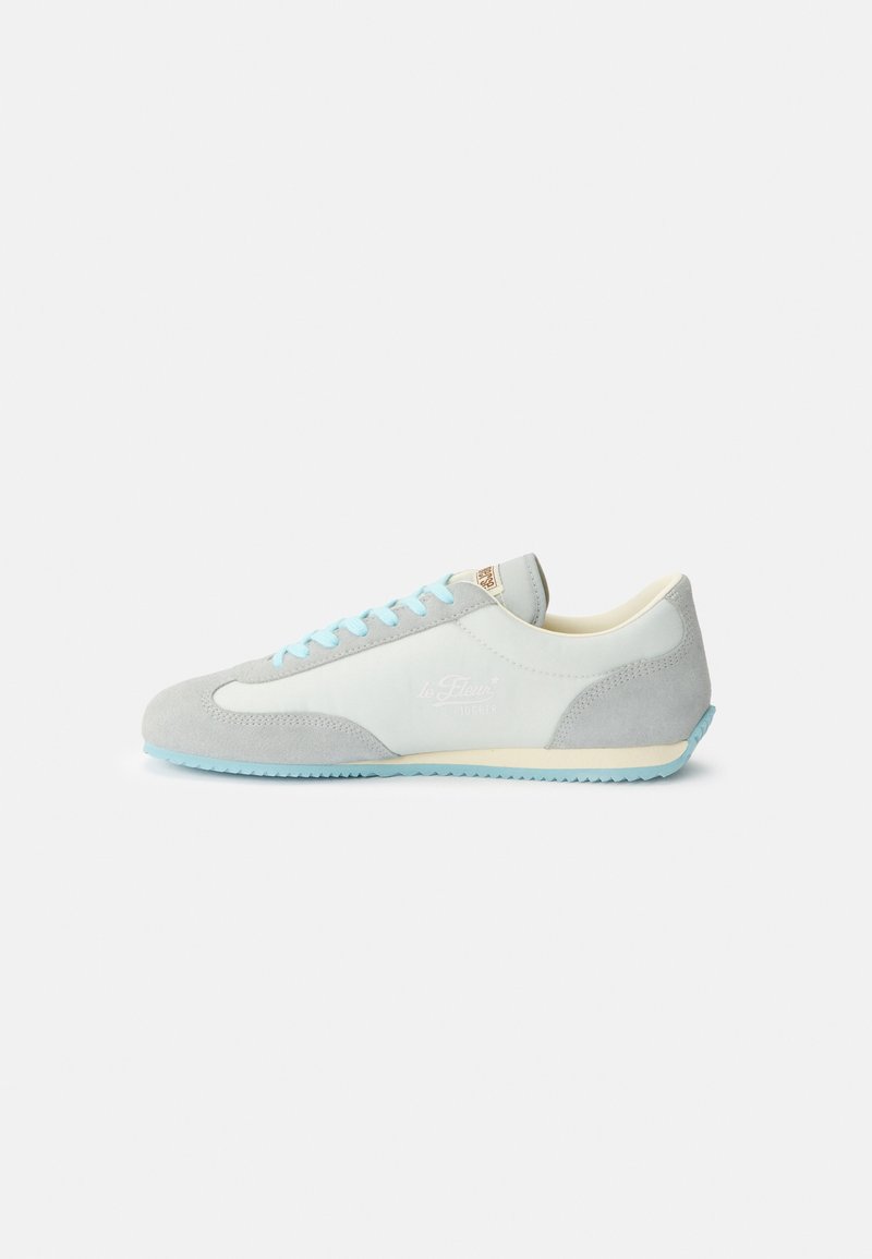 Sneaker basse grigio chiaro e bianco con lacci e suola azzurri, dettagli in suede e logo discreto sul lato.