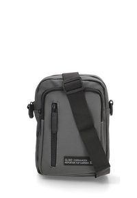 Bolso de hombro gris hecho de tela duradera; cuenta con un bolsillo frontal con cremallera, correa ajustable y parche con logo. Diseño rectangular compacto.