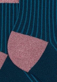 Calzini a righe turchesi e rosa con un tallone rosa lucido. Il tessuto ha una consistenza morbida, con una fine costina e accenti turchesi a contrasto.