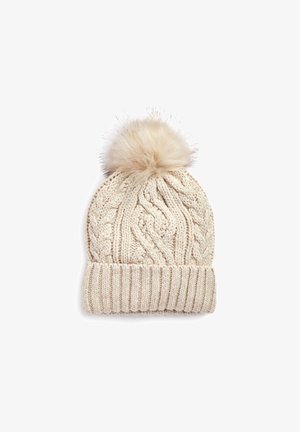 Caciula tricotată bej, cu o manșetă ribbed și un pompon pufoș la vârf, având un model texturat de tricotaj în dantelă pe întreaga suprafață.