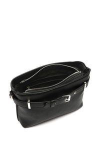 Sac à main en cuir noir avec une fermeture éclair, présentant une texture extérieure et une bandoulière amovible, agrémenté d'accents en métal.