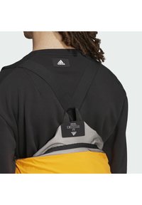Schwarzer Sweatshirt mit einem auffälligen Adidas-Logo, das graue und gelbe Elemente eines angehängten Produkts oder Zubehörs präsentiert.