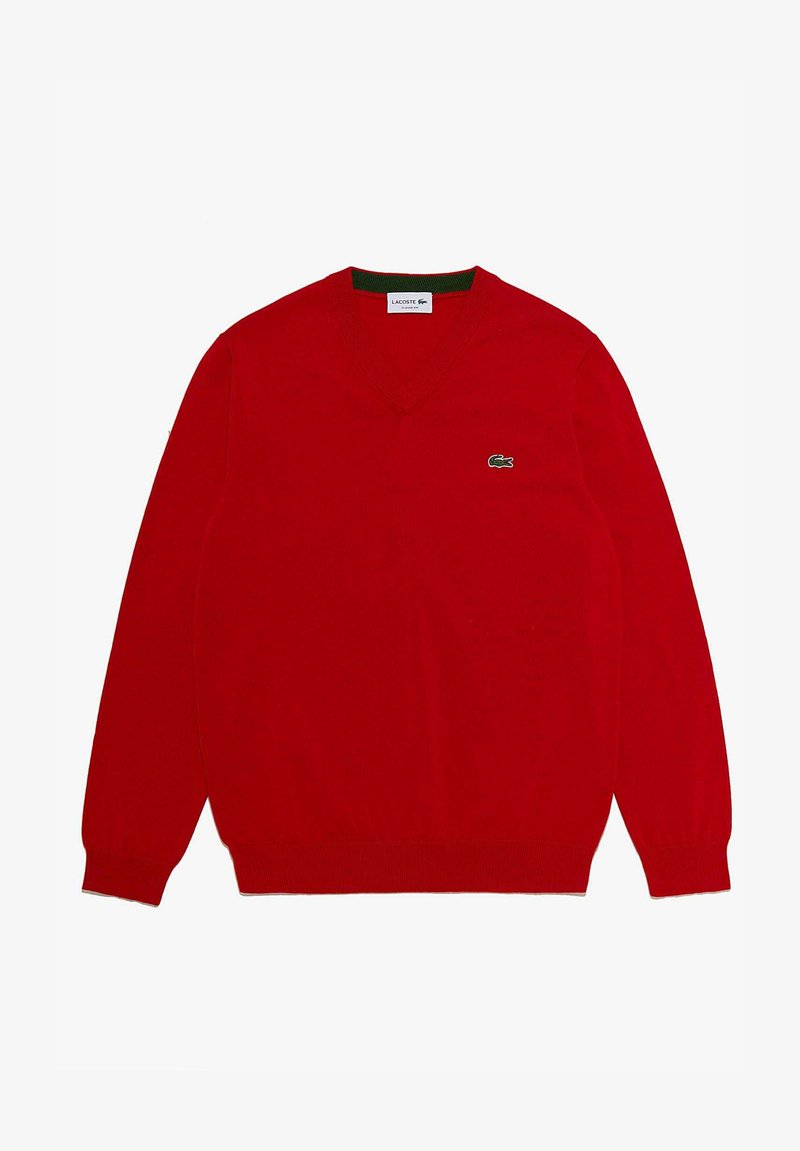 Maglione rosso a scollo a V realizzato in tessuto morbido. Presenta maniche lunghe e un piccolo logo di coccodrillo ricamato in verde sul petto sinistro.