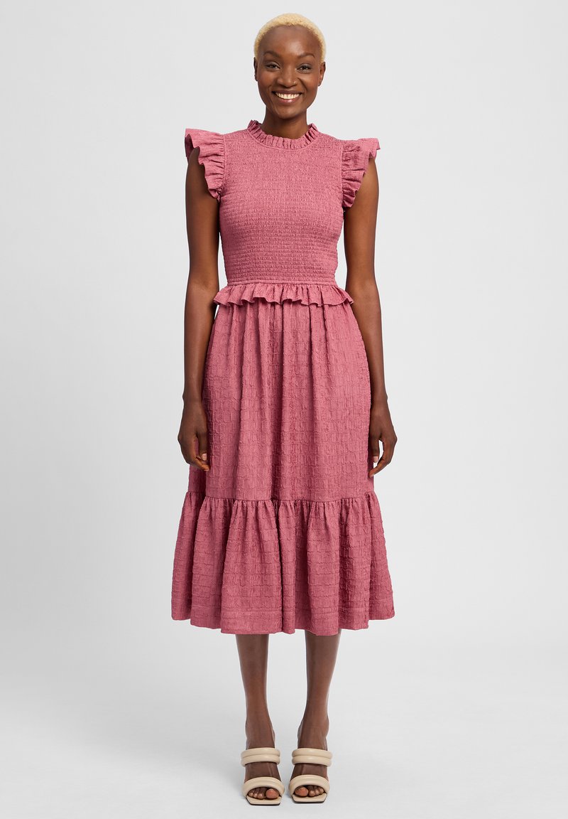 Roze textuur jurk met een geschulpte buste, ruches mouwen en een gelaagde rok. Gedetailleerd met een getailleerde taille en subtiele patronen.
