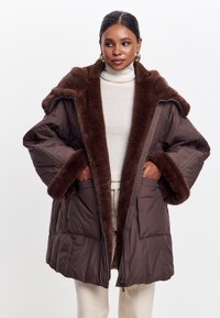 Abrigo acolchado marrón con cuello y puños de piel sintética. Cuenta con grandes bolsillos frontales y cierre de cremallera. Material suave y acolchado.
