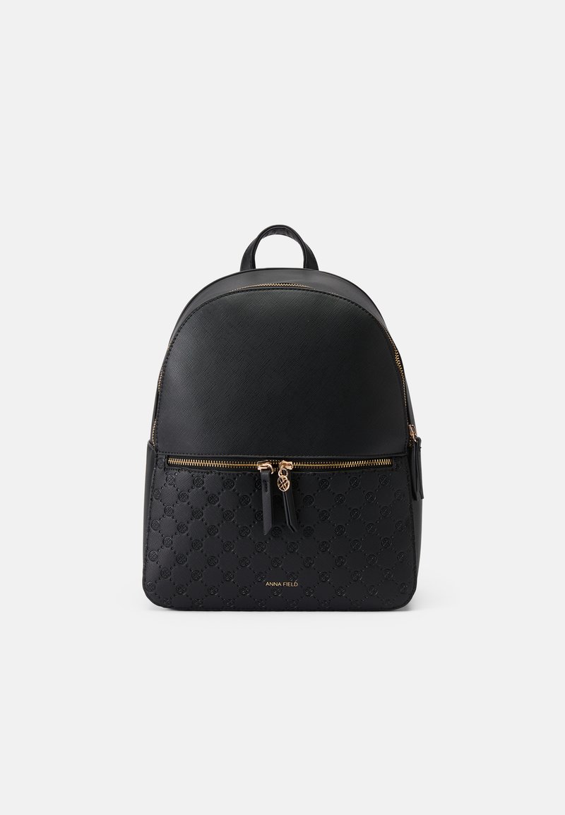 Mochila preta com parte superior em pele suave, secção inferior com padrão e ferragens em tom de ouro. Apresenta um bolso frontal com fecho e detalhes de logotipo.