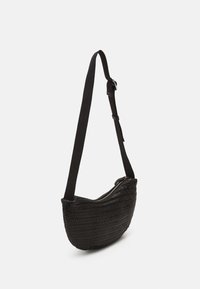 Borsa a spalla nera intrecciata con forma arcuata, tracolla nera regolabile e chiusura con zip, che mostra una superficie testurizzata e un design minimalista.