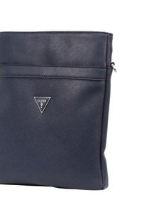Borsa in ecopelle blu navy con finitura testurizzata, dotata di una tasca con zip anteriore e un accento logo triangolare in argento. Bordature lisce e forma strutturata.
