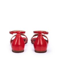 Rode leren sandalen met enkelbandjes, open hiel en uitsnijdingen. Gladde textuur met een lage bruine zool.
