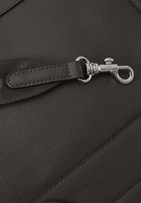 Borsa in pelle nera testurizzata con chiusura in metallo argentato, dettagli di cucitura e un accento in cintura di tessuto piatta.