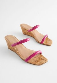 Wedge sandaler med korkbund, pink glansfulde stropper, firkantet tå og en glat inderside. Designet har en minimalistisk to-strop stil.