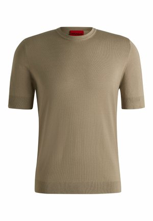 Beige gebreide trui met korte mouwen en een ronde halslijn, voorzien van een subtiele textuur en geribde boorden en onderkant. Merkenlabel in het rood aan de binnenkant.