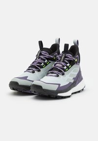 Scarpe da trekking viola e grigio chiaro con suola texturizzata, punta rinforzata e parte superiore in rete, dal design leggero e con accenti riflettenti.