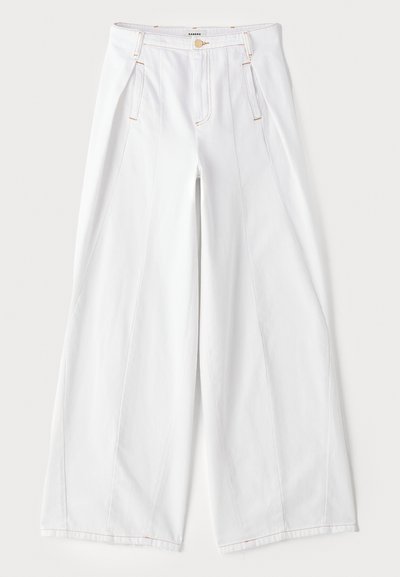 Vide ben bukser i hvid denim med kontrast- orange syninger, frontfolder og et klassisk fem-lommes design.