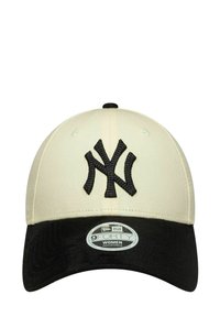 Cappello crema con visiera nera, presenta un ricamo con il logo "NY" nero. Il materiale è tessuto, progettato con una forma strutturata e una vestibilità regolabile.