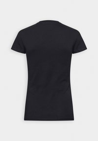 Camiseta de algodón negra de manga corta, con cuello redondo y forma ajustada; textura suave sin patrones visibles ni elementos metálicos.