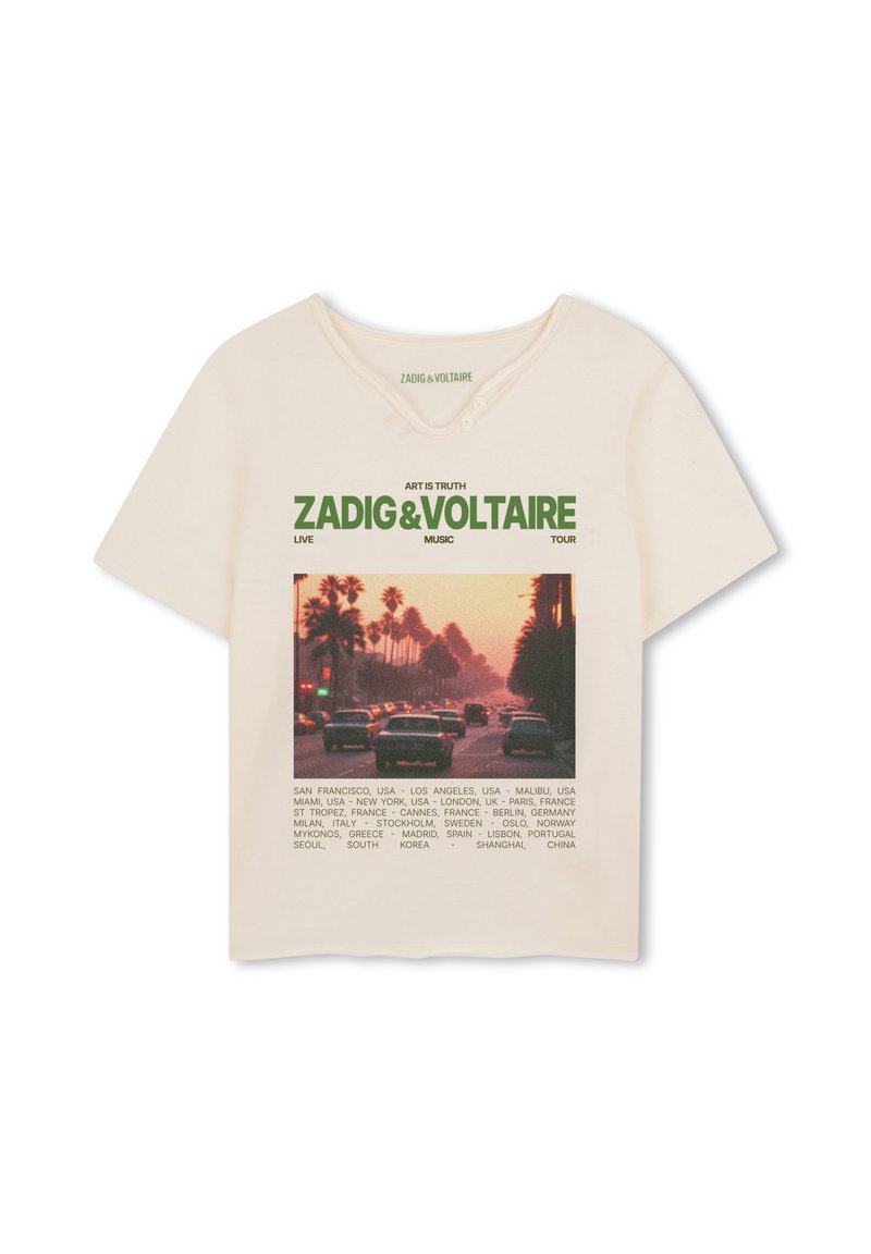 Μπεζ βαμβακερό t-shirt με γραφικό σχέδιο από μια σκηνή δρόμου σε ηλιοβασίλεμα και πράσινο κείμενο. Διαθέτει χαρακτηριστικό στρογγυλό ντεκολτέ και κοντά μανίκια.