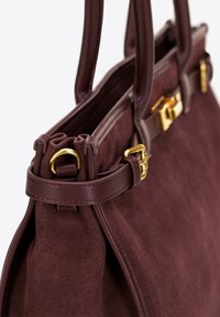 Burgunderfarbene Wildleder-Handtasche mit doppelten Ledergriffen, goldenen Hardware-Details und einem plissierten Design mit einem gesicherten Oberverschluss.