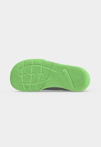 Πράσινη υφασμάτινη σόλα παπουτσιού Nike με ορατό λογότυπο Nike Swoosh, απομονωμένη σε ανοιχτό φόντο.