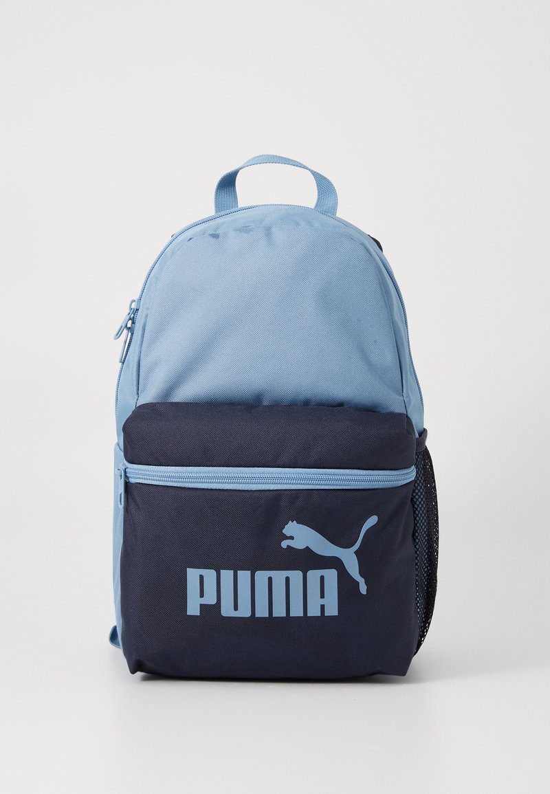 Ένα ανοιχτό μπλε και ναυτικό σακίδιο πλάτης με μία μπροστινή τσέπη που έχει το λογότυπο της Puma σε μπλε χρώμα, τοποθετημένο σε λευκό φόντο.
