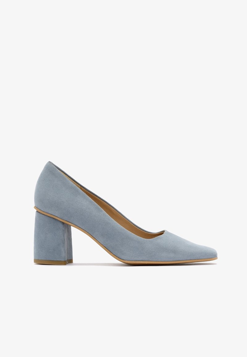 Escarpin en daim bleu clair avec un bout rond et un talon bloc épais. Texture lisse et design minimaliste.