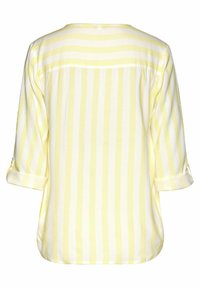 Blusa a righe gialle e bianche con una vestibilità morbida, maniche a tre quarti e polsini risvoltati. Tessuto morbido, leggero, con una texture liscia.