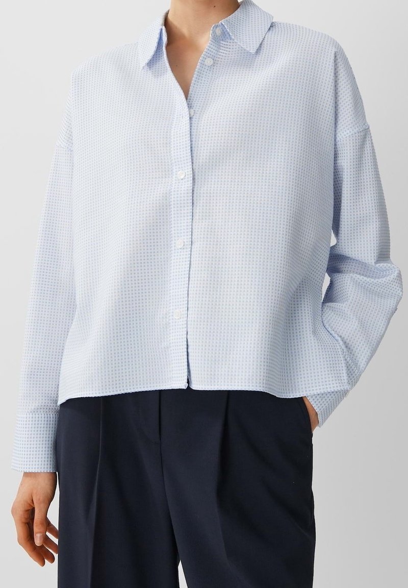 Ljusblå knapp-up skjorta med rutmönster, långa ärmar, krage och en avslappnad passform. Tillverkad av mjukt, lätt tyg.