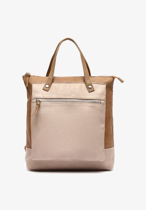 Sac fourre-tout en cuir bicolore beige et marron avec poche zippée à l'avant et poignées doubles, debout sur un fond blanc.