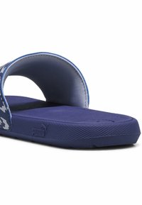 Blå halksandaler med ett mönstrat rem. Tillverkade av gummi, med en texturerad sula och en PUMA-logotyp på sidan. Rundad, öppen tådesign.