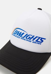 Hvit caps med svart brem som har en blå og oransje logo med teksten "LOWLIGHTS ENHANCED RACING GEAR." Glatt stoffoverflate med sømdetaljer.