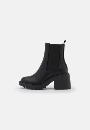 Schwarzer Leder-Stiefelette mit klobigem Blockabsatz, elastischen Seitenteilen, Zuglasche hinten und strukturierter Sohle.