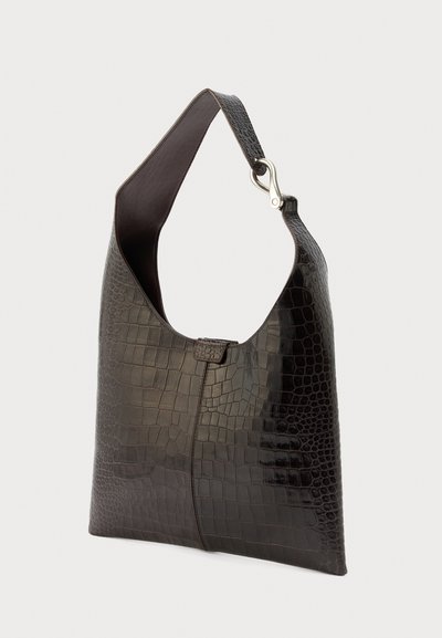Μαύρη τσάντα χειρός από δέρμα με ανάγλυφο μοτίβο κροκοδείλου, με φαρδιά τιράντα και ασημένιο κούμπωμα στη μία πλευρά, εμφανίζεται σε απλό φωτεινό φόντο.