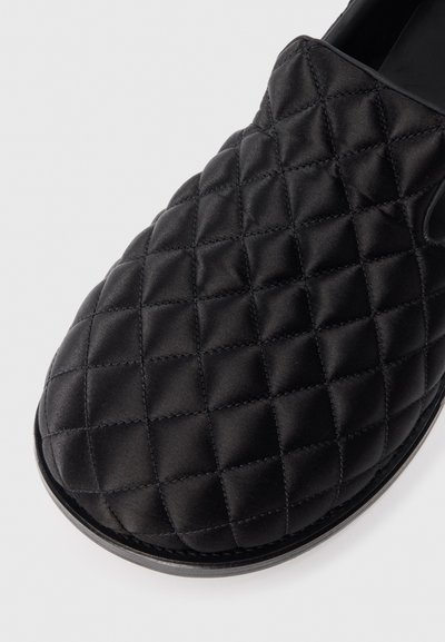 Svart quiltad satin slip-on sko med rund tå och slät sula. Har ett rutmönster sydd över övre delen för textur.