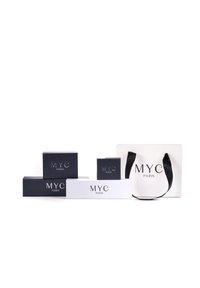 Zwarte en witte verpakkingsdozen met "MYC PARIS" in zilver erop gedrukt. Inclusief een witte tas met zwarte handvatten; in verschillende maten en vormen.