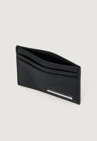 Crni kožni držač za kartice s teksturom, s tri utora za kartice i metalnom pločicom s logotipom "Armani Exchange" sprijeda.