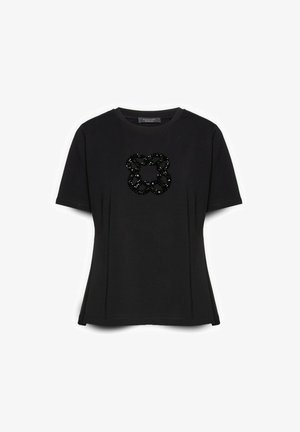 Schwarzes, eng anliegendes T-Shirt mit kurzen Ärmeln, rundem Ausschnitt und einem glänzenden schwarzen Perlen-Blumendesign, das auf der Brust zentriert ist.