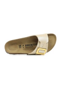 Sandale à glissière Birkenstock en cuir crème avec une large sangle et une boucle dorée, dotée d'une semelle intérieure profilée marron et d'une semelle en liège naturel.