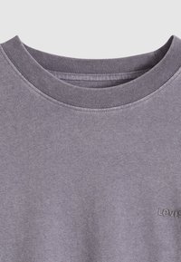 Γκρι κοντομάνικο μπλουζάκι με κλασικό στρογγυλό λαιμόκοψη και διακριτή υφή, με κεντημένο λογότυπο στο κάτω αριστερό μέρος.