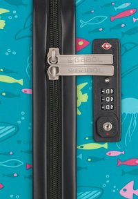 Valigia rigida di colore turchese con motivi di pesci. Caratterizzata da doppie chiusure a zip e una combinazione nera con porta chiave.