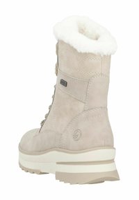 Stivale beige in suede con colletto in pelliccia sintetica, parte anteriore con lacci e suola in gomma texture. Presenta un logo e dettagli di cucitura sul lato.