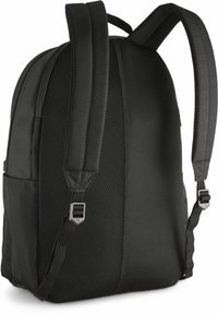 Mochila negra con paneles de malla acolchados, correas ajustables y un bolsillo lateral. Presenta un diseño elegante y redondeado con una textura suave.