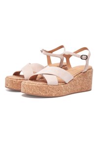 Beige platform sandals with a cork sole, featuring crossed suede straps and an adjustable ankle strap with a silver buckle detail.