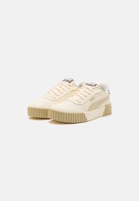 Beżowe sportowe sneakersy z teksturowanej skórzanej cholewki, tonowe sznurowadła i masywna gumowa podeszwa. Posiadają subtelne oznakowanie na języku i boku.