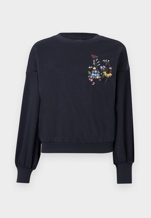 Sweat-shirt bleu marine à manches longues avec poignets et ourlet côtelés, ornée d'une broderie colorée de fleurs et de papillons sur le côté gauche de la poitrine.