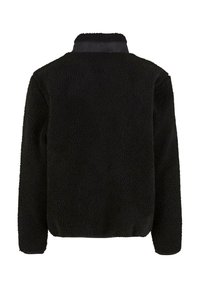 Czarna polarowa kurtka z teksturową powierzchnią, miękkim wykończeniem i kontrastowym kołnierzem. Posiada luźny krój i długie rękawy.