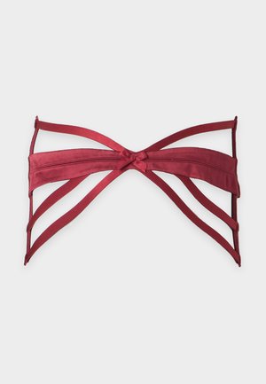 Haut de bikini bandeau rouge à fines bretelles avec un détail de nœud central, présenté à plat sur fond blanc.