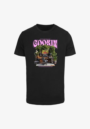 Must musta mustra musta must to, näiteks musta puuvillane T-särk, millel on värvikas graafika sõnaga "COOKIN" roosas, ümbritsetud lauast, millel on taimed, kõlarid ja varustus.