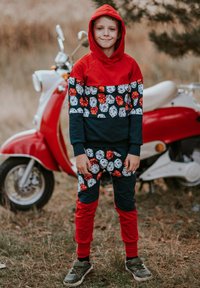 Czerwono-granatowy zestaw bluza z kapturem i spodnie z wzorem kostek do gry, wykonany z miękkiej tkaniny, z ściągaczami na mankietach i kieszenią kangurka.