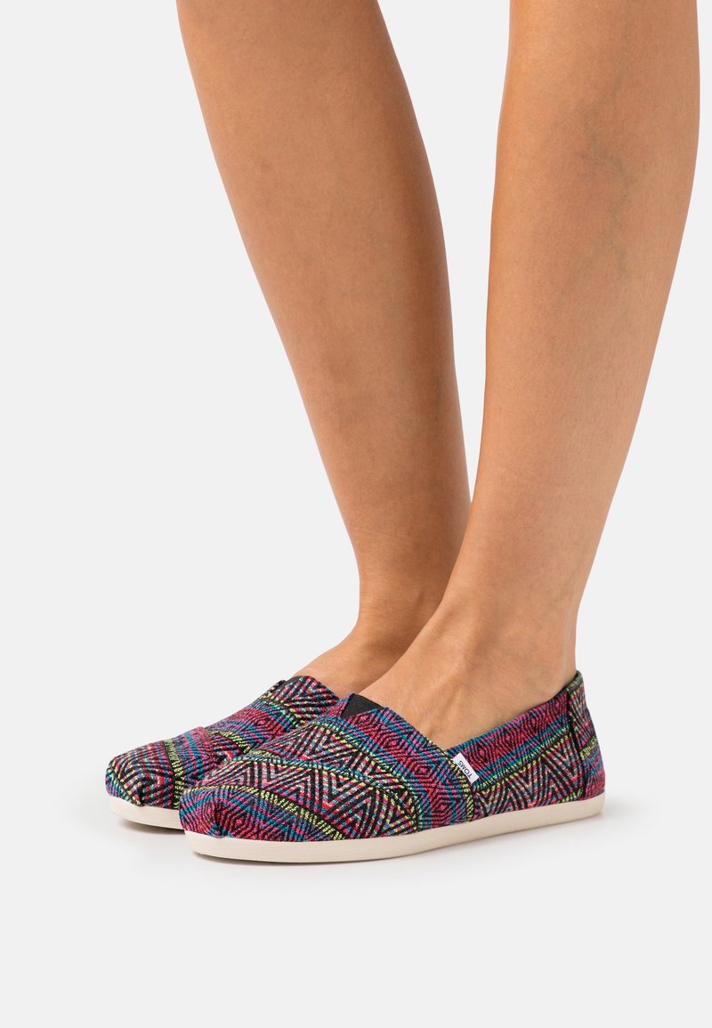 Scarpe slip-on multicolori con motivo geometrico, tomaia in tessuto e suola in gomma bianca. Texture morbida con un design a profilo basso.